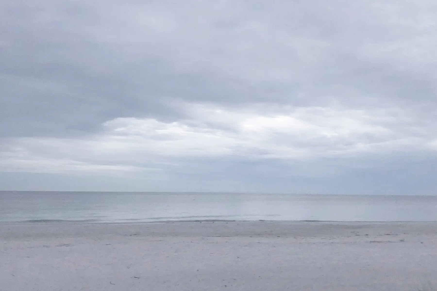 A quiet shoreline beneath a blue-gray sky