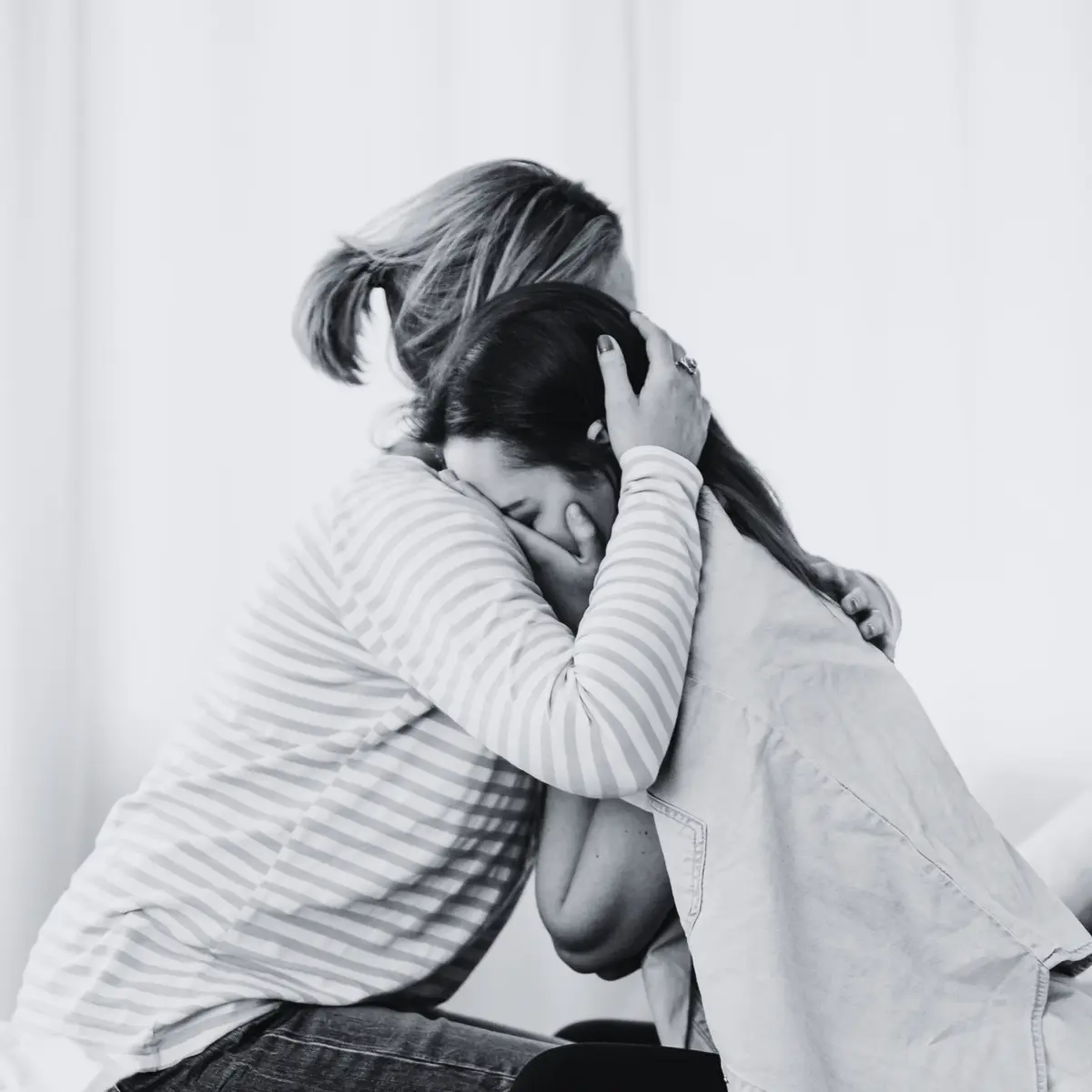 Two women holding one another in comfort